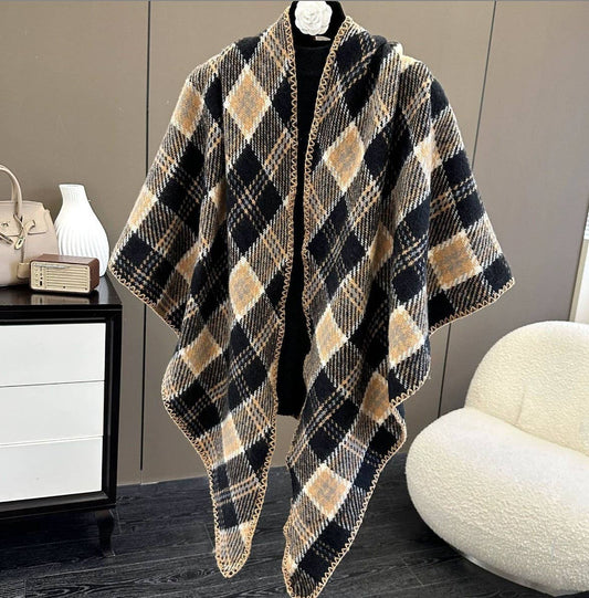 Plaid poncho draped over a mannequin against a neutral background